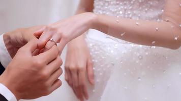 jeune marié en mettant mariage bague sur doigt de la mariée. photo