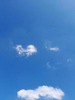 beaux nuages blancs sur fond de ciel bleu profond. de grands nuages doux et moelleux couvrent tout le ciel bleu. photo