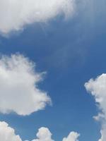 beaux nuages blancs sur fond de ciel bleu profond. de grands nuages doux et moelleux couvrent tout le ciel bleu. photo