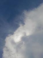 beaux nuages blancs sur fond de ciel bleu profond. de grands nuages doux et moelleux couvrent tout le ciel bleu. photo