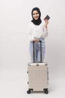 une Jeune musulman femme touristique avec bagages sur blanc Contexte photo