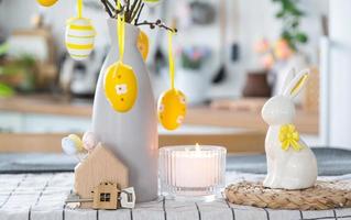 clé à maison de confortable Accueil avec Pâques décor avec lapin et des œufs sur table de cuisine. bâtiment, conception, projet, en mouvement à Nouveau loger, hypothèque, assurance, location et achat réel biens photo