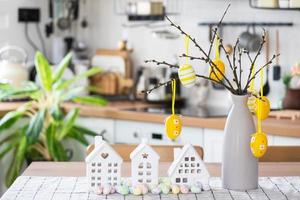 clé à maison de confortable Accueil avec Pâques décor avec lapin et des œufs sur table de cuisine. bâtiment, conception, projet, en mouvement à Nouveau loger, hypothèque, assurance, location et achat réel biens photo