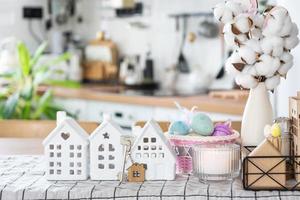 clé à maison de confortable Accueil avec Pâques décor avec lapin et des œufs sur table de cuisine. bâtiment, conception, projet, en mouvement à Nouveau loger, hypothèque, assurance, location et achat réel biens photo