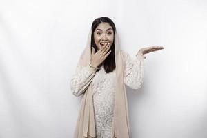 sous le choc asiatique musulman femme montrer du doigt à le copie espace sur à côté de son, isolé par blanc Contexte photo