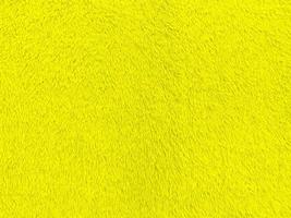 texture de tissu de velours jaune utilisée comme arrière-plan. fond de tissu jaune vide de matière textile douce et lisse. il y a de l'espace pour le texte. photo