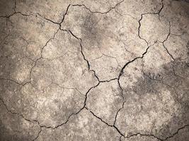 surface du sol fissuré, surface rugueuse brune, selon le concept de sécheresse ou de manque d'humidité. adapté à l'arrière-plan photo