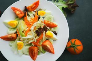 Frais salade avec tomates et Oeuf sur noir Contexte. en bonne santé nourriture concept. photo
