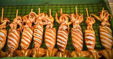 grillé calamar sur gril avec brochette des bâtons dans rue nourriture photo