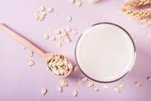 fermer de avoine Lait dans une verre et flocons d'avoine sur le tableau. alternative à lactose. Haut vue photo