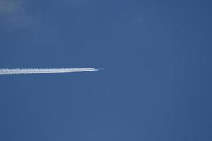 un avion et des traînées de vapeur dans le ciel photo