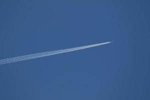 un avion et des traînées de vapeur dans le ciel photo