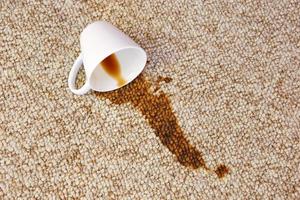 tasse de café est tombée sur tapis. tache est sur sol. photo