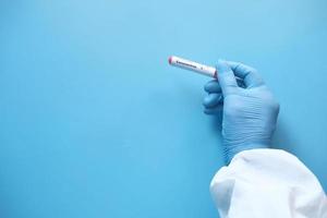 main de technicien de laboratoire tenant le tube à essai de sang
