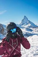 Jeune snowboarder dépenses hiver vacances dans zermatt, près le célèbre Matterhorn culminer. Masculin posant dans Suisse Alpes pour le planche a neige saison. photo