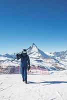 Jeune skieur profiter Zermatt ski station balnéaire. magnifique ensoleillé journée avec une skieur en haut dans le montagnes. des sports modèle. photo