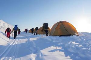groupe de Montagne grimpeurs montée le pente à le de pointe dans ensoleillé temps avec traîneaux et tentes équipement pour pendant la nuit séjours photo