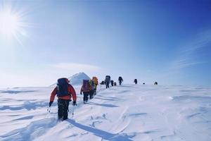 groupe de Montagne grimpeurs montée le pente à le de pointe dans ensoleillé temps avec traîneaux et tentes équipement pour pendant la nuit séjours photo