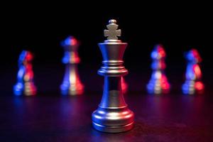 échecs du roi d'or debout devant d'autres échecs, le concept d'un leader doit avoir du courage et du défi dans la compétition, le leadership et la vision commerciale pour gagner dans les jeux d'entreprise photo