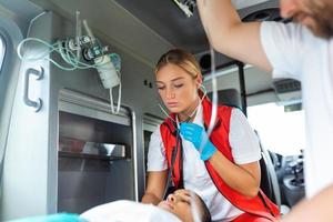 Jeune médecin avec stétoscope écoute patient cœur et poumons. photo