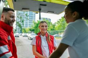 équipe de ambulanciers prise une Pause dans un ambulance Extérieur, attendre pour une appel. photo