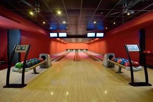 boules de bowling et pistes en bois dans une salle de bowling photo