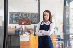 portrait de une femme, une café magasin affaires propriétaire souriant magnifiquement et ouverture une café magasin cette est sa posséder entreprise, petit affaires concept. photo