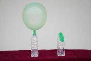 science expérience , vert gonflé des ballons et plat ballon sur Haut de transparent tester bouteilles. concept, science expérience à propos réaction de chimique substance, le vinaigre et cuisson un soda. photo