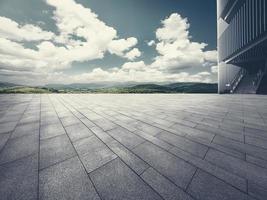 le vide brique carré et bâtiment partie avec bleu ciel et Montagne Contexte. photo