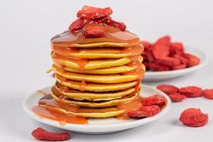 Crêpes avec framboises et caramel sur une blanc assiette photo