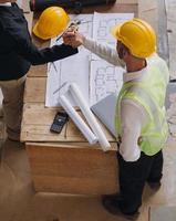 diverse équipe de spécialistes utilisation tablette ordinateur sur construction placer. réel biens bâtiment projet avec civil ingénieur, architecte, affaires investisseur et général ouvrier discuter plan détails. photo