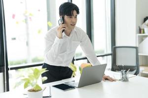 souriant jeune homme d'affaires parlant au téléphone. photo