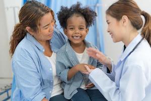 le fille est assis sur le les patients lit pour le médecin. photo