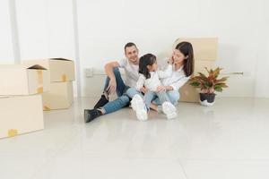 content famille avec fille en mouvement dans une Nouveau maison. photo