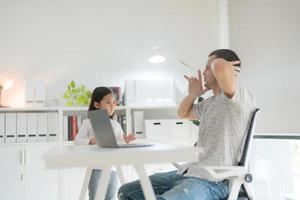 père en essayant à travail à Accueil Bureau et fille. photo