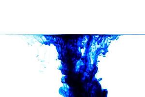 bleu encre laissez tomber dans l'eau. fond, eau laissez tomber collision avec abstrait effet.bleu encre isolé dans l'eau photo