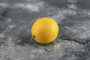 un citron jaune mûr sur fond de marbre photo