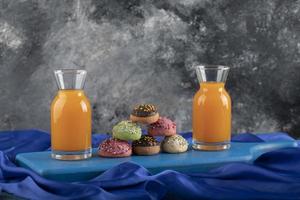 beignets sucrés colorés avec des pots en verre de jus photo