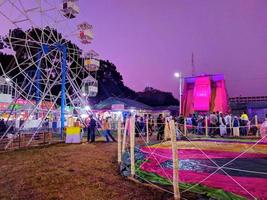 nuit coup de une ferris roue dans exposition fair.people et champ de foire monte à le le plus gros équitable. ferris roue à local comté juste.coloré Commerce juste dans rangpur. photo