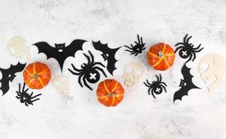 Halloween fête flatlay avec citrouilles, chauves-souris, araignées et crânes. fond bannière. octobre 31 concept photo