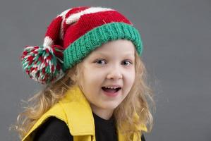 marrant peu fille dans une Noël chapeau. portrait de une de bonne humeur et content enfant. photo