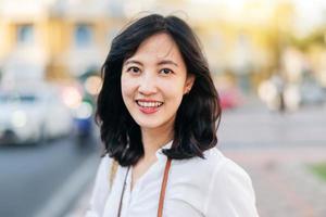 portrait magnifique asiatique femme voyageur souriant et à la recherche à caméra tandis que explorer rue sur été vacances dans Bangkok, Thaïlande photo