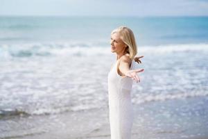 femme mûre ouvrant ses bras sur la plage, passant son temps libre, profitant de son temps libre photo