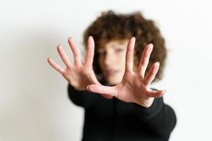 défocalisé femme élongation bras et montrant Arrêtez geste avec plein ouvert paumes photo