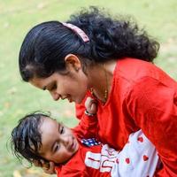 aimant maman porter de sa bébé à société parc. brillant portrait de content maman en portant enfant dans sa mains. mère étreindre sa peu 9 mois vieux fils. photo