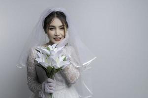 portrait de asiatique femme porter la mariée avec fleur sur blanc arrière-plan, mariage concept photo