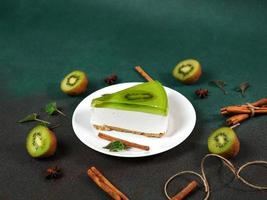 cheesecake avec kiwi, cannelle bâton et feuilles menthe sur une vert Contexte. copie cpase pour texte photo