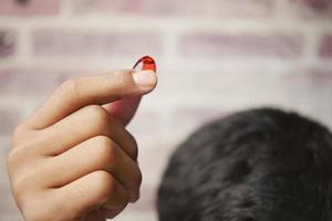 hommes appliquant de l'huile de capsule sur les cheveux photo