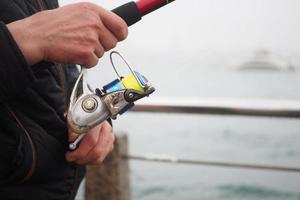 pêcheur avec canne à pêche, filage bobine , photo