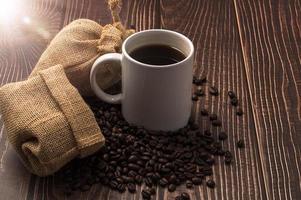 une tasse de café et des grains de café sur une table en bois photo